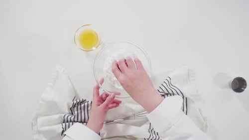 Icing Preparation with Whisk and White Tablecloth
