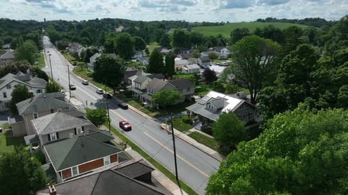 Homes along quiet street in summer. Aerial establishing shot on summer afternoon.