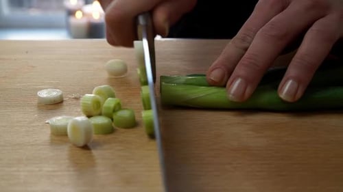 Chopping Fresh Green Onions on Wooden Cutting Board