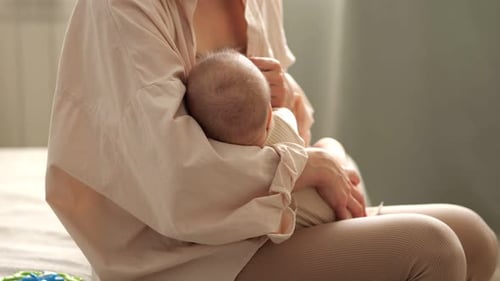 Loving Mother Breastfeeding Her Baby at Home
