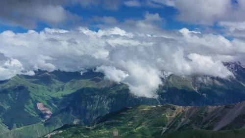 Aerial View of Verdant Mountains Under Cloudy Skies