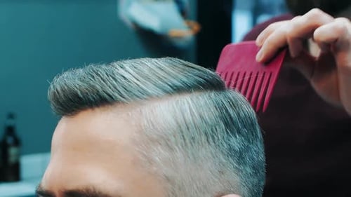 Man Getting Haircut by Barber in Barbershop