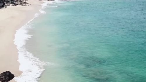 Drone aerial moving forward white sand blue water beach Hawaii