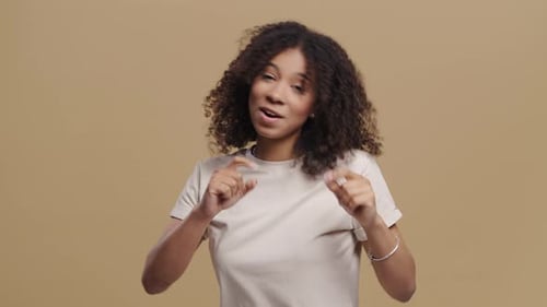 Happy African Woman Dancing On Beige Studio Background Favorite Music Smiling