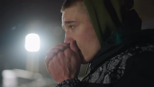 Homme froid soufflant de l'air chaud dans les mains par une nuit glaciale
