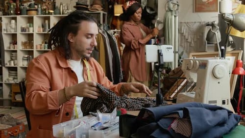 Male Second Hand Shop Owner Recording Tutorial on Upcycling Old Clothes
