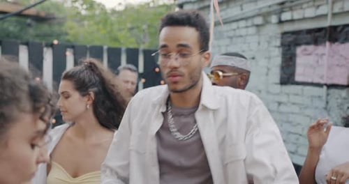 Cheerful African American Man Dancing in Open Air Cafe Enjoying Leisure Time with Friends