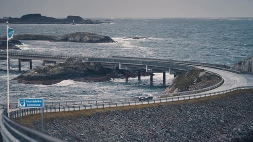 Famous Atlantic ocean road winding through the archipelago. Powerful waves crash on the rocks and br
