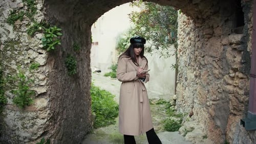 Woman Under The Arch Of A Medieval Town Taking Notes