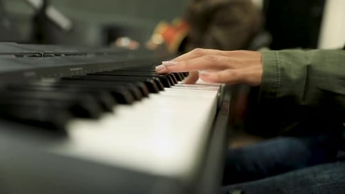 Close-up of a female hands playing the piano in the studio