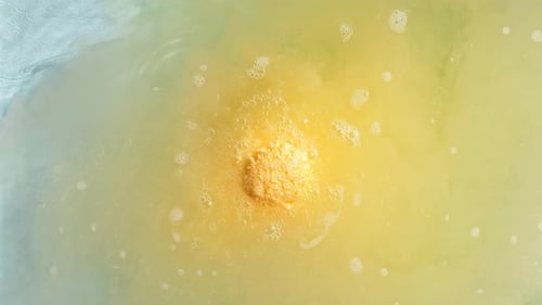 Yellow Bath Bomb Dissolving in Water