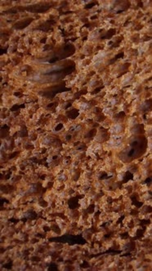 Background of Black Bread Rotating Extreme Close Up Macro Shot Vertical Video