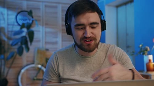 Young Adult Talking on Laptop with Headphones