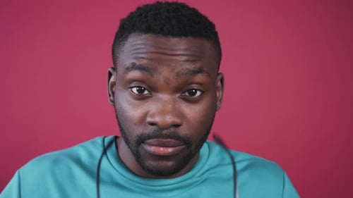 Gesicht eines jungen süßen afrikanischen Mannes mit braunen Augen Gut aussehender kluger Kerl, der aufmerksam in die Kamera schaut