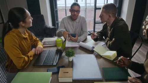 Young Inspired Diverse Startup Team Discussing New Project at Table in Office