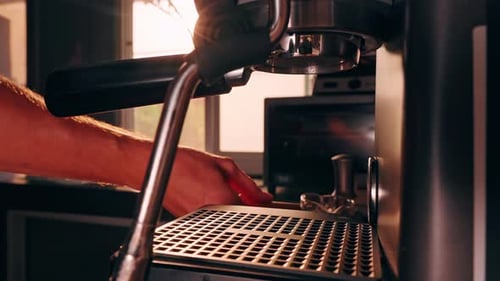 Barista Placing Measuring Glass Cup under Espresso Machine Group Head in Slow Motion, Close View of