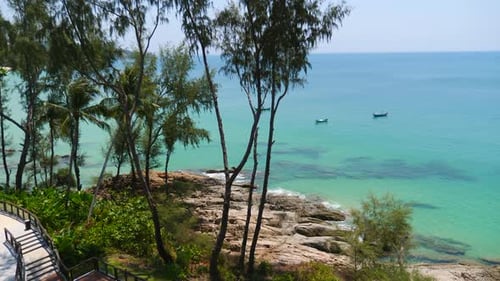 Ruhiger tropischer Strand mit klarem türkisfarbenem Wasser und Fischerbooten