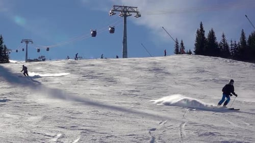 Ski Lift and Skiers on a Sunny Slope
