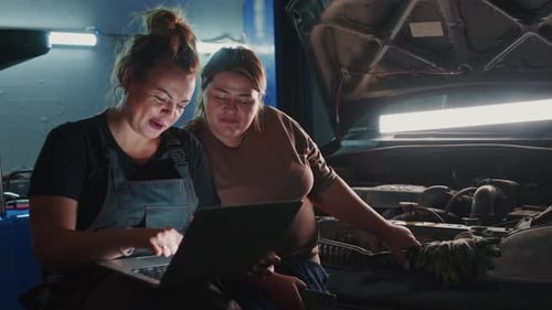 Women Learning Automotive Skills Together in a Garage at Night