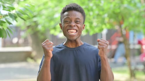 Young Adult Cheers with Excitement Outdoors