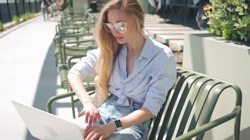 Freelancer with Laptop Sitting on Outdoor Cafe Terrace