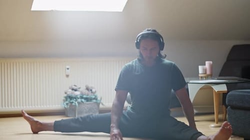 Man Stretching in Straddle Split Wearing Headphones