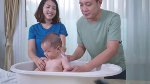 Loving Parents Giving Infant a Gentle Bath