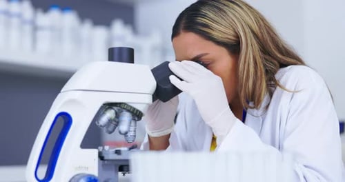 Woman Scientist Using Microscope in Modern Lab