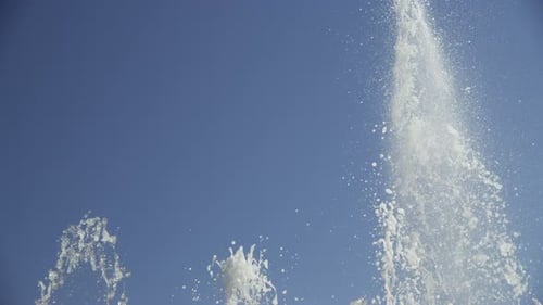 Wasser aus dem Springbrunnen spritzt in den Hintergrund des klaren Himmels