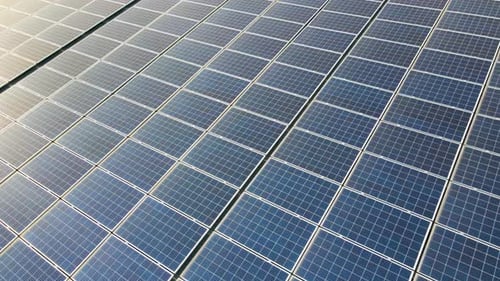 Closeup of Surface of Blue Photovoltaic Solar Panels Mounted on Building Roof for Producing Clean