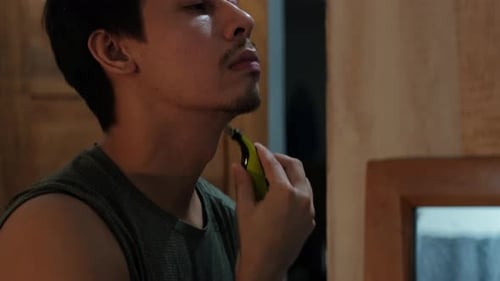 Close-Up of Young Man Shaving Neck With Razor Indoors, Grooming Routine