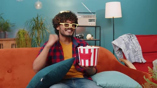 Young Adult Enjoys Movie and Popcorn at Home