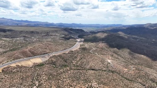 Aerial view of desert landscape with mountains and winding road, United States.