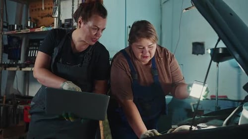 Women Mechanics Working Together on a Car in an Auto Repair Shop