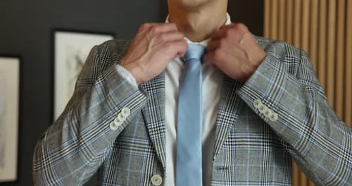 Man tying stylish necktie at home, closeup