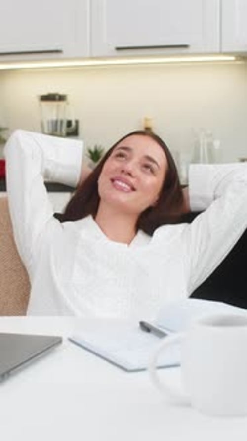 Woman Working on Laptop in Kitchen Relaxes