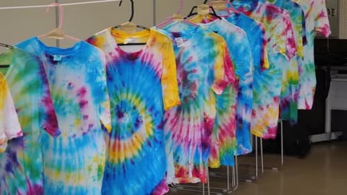Row of Tie-Dye Shirts Hanging on Rack