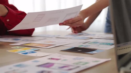 Team Discussing Mobile App Designs in Modern Office