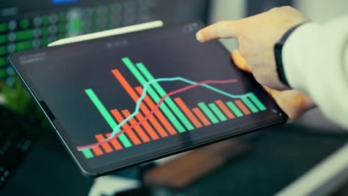 Man Analyzes Business Data Chart on Tablet Device