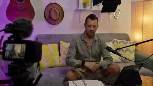 Content creator recording tutorial for his online channel from home studio.