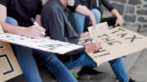 Un groupe de personnes préparant une manifestation signe des cartels en cas de crise financière et d'inflation mondiale en plein air