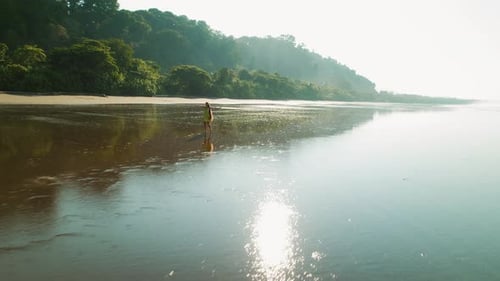 Girl twirls in dress on wet sand of Playa Hermosa beach during Costa Rica trip
