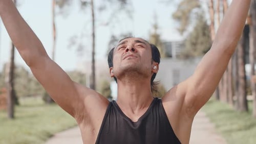 Young Asian Male Sportsman Performing Warming Up Exercise Before Run and Tuning Up for Good Workout