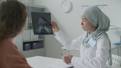 Doctor Explains X-Ray to Patient in Medical Office