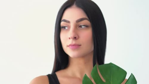 Woman Posing with Leaf Against White Background