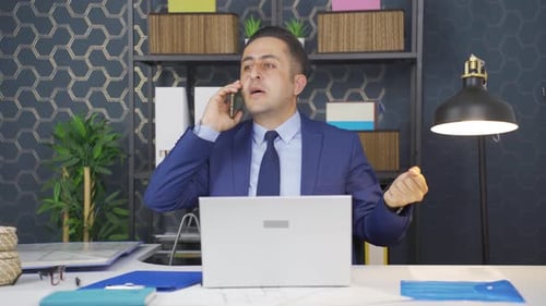Frustrated Businessman Arguing on Phone in Office