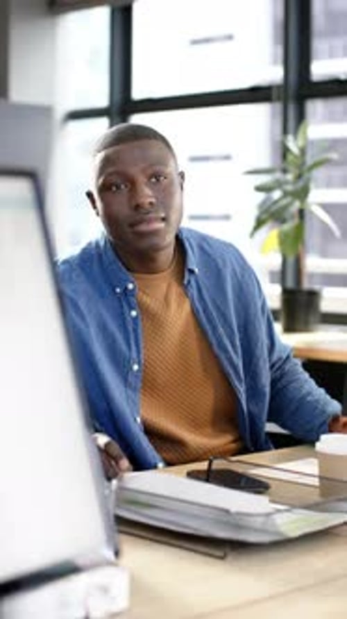 Vertical video of african american businessman working in office, slow motion, copy space