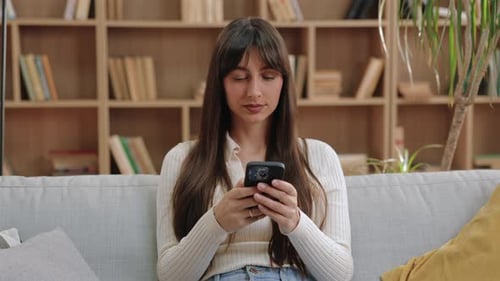 Woman Relaxing on Couch Using Mobile Phone