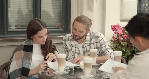 Group of Friends Talk Over Coffee at Outdoor Cafe