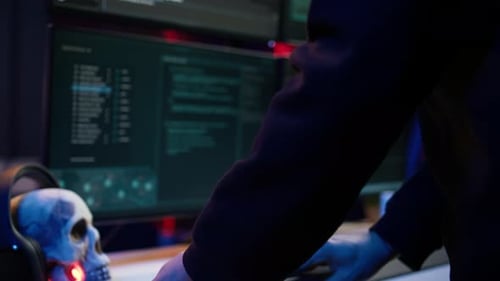 Hooded Hacker Taking Laptop Out of Suitcase Prepared to Launch DDoS Attack